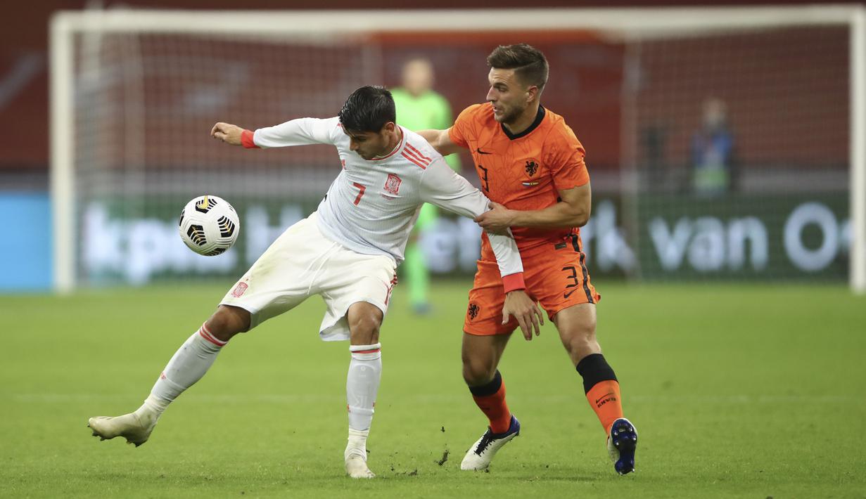 Penyerang Spanyol, Alvaro Morata berebut bola dengan bek Belanda, Joel Veltman dalam laga persahabatan internasional di Johan Cruijff ArenA, Amsterdam, Kamis dinihari WIB (12/11/2020). Kedua tim bermain sama kuat 1-1. (Dean Mouhtaropoulos/Pool via AP)