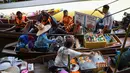 Pedagang menghampiri wisatawan yang sedang naik kapal di pasar terapung Damnoen Saduak, Bangkok, Thailand, Jumat (21/6/2019). Damnoen Saduak menjadi pasar terapung yang wajib Anda datangi saat berwisata ke Negeri Gajah Putih. (TANG CHHIN Sothy/AFP)
