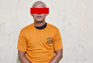Pelaku AT diamankan polisi setelah kepergok merekam tetangganya sendiri saat mandi di sebuah rumah kontrakan di Bandar Lampung. (Istimewa).