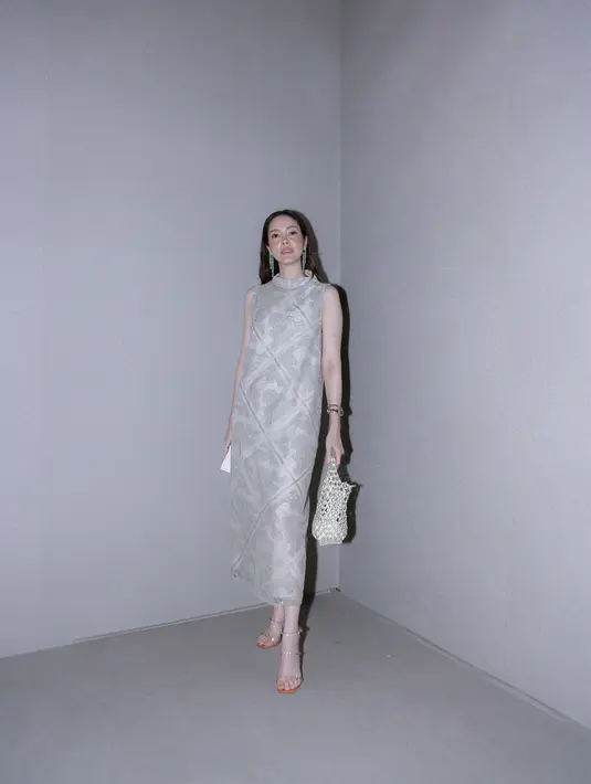 Cathy Sharon tampil elegan dengan dress bernuansa keemasan. Dress panjang tanpa lengan yang dikenakannya memiliki aksen leher bulat, serta ia padukan dengan tas keranjang, serta open-toe heels yang juga bernuansa keemasan yang serasi. [Foto: Document/FIMELA]