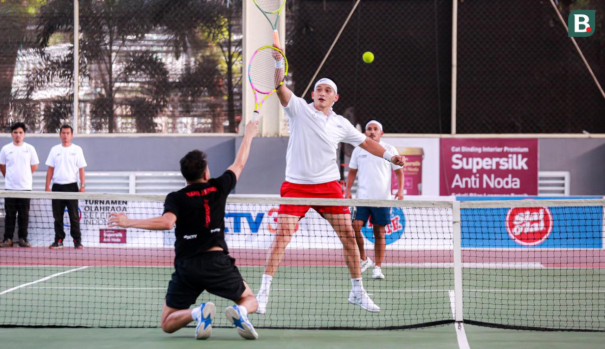 Selebritas Indonesia, Rezky Aditya berusaha mengembalikan bola ke arah pasangan Raffi Ahmad dan Deddy Mahendra Desta pada laga tenis nomor ganda putra Turnamen Olahraga Selebriti Indonesia di GOR UNJ, Jakarta, Minggu (30/07/2023). Rezky yang berpasangan dengan Tanta Ginting kalah dengan skor 6-4, 4-6, dan 4-6. (Bola.com/Bagaskara Lazuardi)
