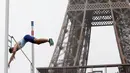 Atlet asal Inggris Joel Leon Benitez lakukan lompat gajah di depan Menara Eiffel, taman Champs de Mars, Paris, Rabu (13/9). Warga kota Paris sambut Olimpiade musim panas 2024 dengan mengadakan berbagai jenis kompetisi olahraga. (AP Photo/Thibault Camus)