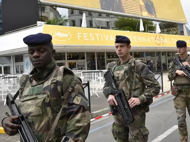 Sejumlah tentara Prancis berpatroli di depan Festival Palace di Cannes, Selasa (10/5/2016). Penyelenggaraan Festival Film Cannes 2016 yang akan dimulai pada 11-12 Mei 2016 hingga kini masih dirundung kekhawatiran. (Loic VENANCE/AFP)