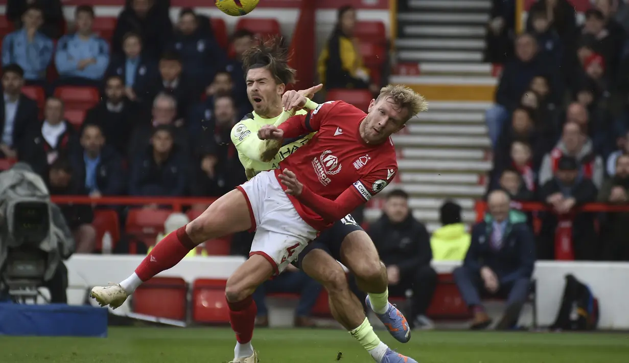 Gelandang Manchester City, Jack Grealish berebut bola dengan pemain Nottingham Forest, Joe Worrall selama pertandingan Liga Premier Inggris di  Stadion City Ground, Nottingham, Inggris, Sabtu (18/2/2023). Man City kini duduk di urutan kedua via catatan 52 angka, tertinggal dari Arsenal yang berada di puncak klasemen dengan 54 poin. (AP Photo/Rui Vieira)