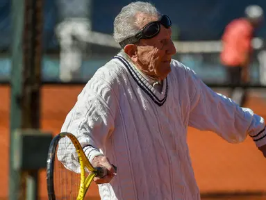 Artyn Elmayan, seorang pria asal Armenia, bermain tenis di River Plate Club di Buenos Aires, Selasa (16/5). Meski usianya telah mencapai 100 tahun, Artyn mengaku tetap rutin main tenis tiga kali seminggu. (AFP FOTO / Eitan ABRAMOVICH)