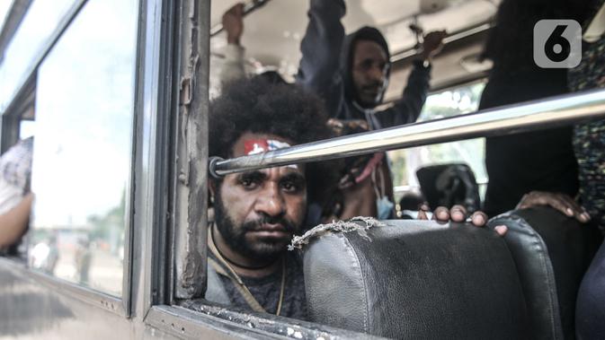 Seorang massa FRI-West Papua menaiki bus saat dibubarkan oleh aparat kepolisian terkait aksi peringatan Deklarasi 1 Desember 1961 di kawasan Monas, Jakarta, Selasa (1/12/2020). Aksi massa tidak berlangsung lama karena dibubarkan oleh aparat kepolisian. (merdeka.com/Iqbal S. Nugroho)