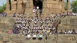 Para siswa mengikuti sesi yoga untuk menandai Hari Yoga Internasional di Kuil Matahari di Modhera, India (21/6). Seluruh dunia pada 21 Juni memperingati Hari Yoga Internasional tahunan yang keempat. dimulai. (AFP Photo/Sam Panthaky)