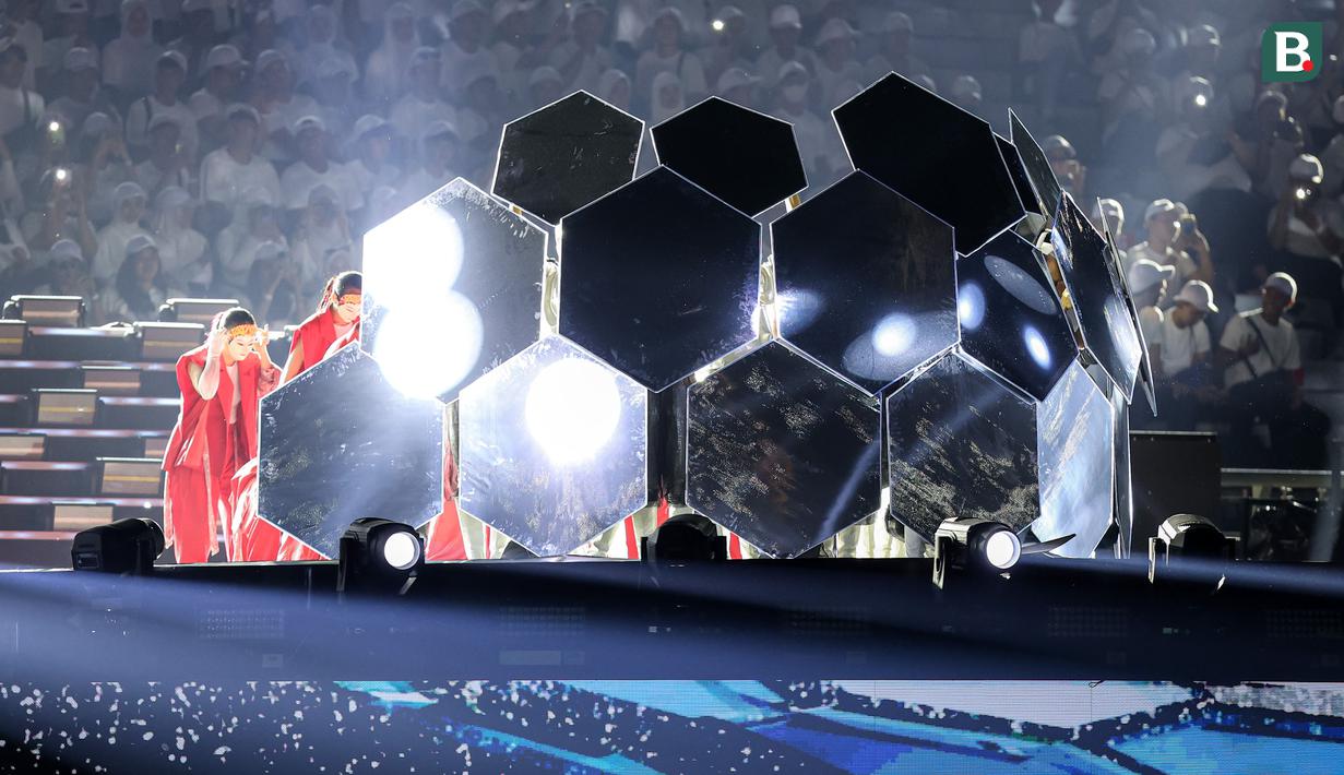 Kepingan bola raksasa terbuka saat penyanyi Aurelie Moeremans muncul untuk mengisi acara pembukaan Piala Dunia U-17 2023 di Stadion Gelora Bung Tomo, Surabaya, Jumat (10/11/2023) malam WIB. (Bola.com/Bagaskara Lazuardi)