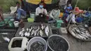 Etnis Vietnam menjual ikan di sepanjang trotoar dekat desa Prek Pnov di Phnom Penh, Kamboja, Kamis (5/8/2021). Prek Pnov terkenal dengan peternakan ikannya dan memasok banyak pasar di Phnom Penh. (AP Photo/Heng Sinith)