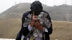 Pria memakai topeng dan membawa uang selama melakukan tetrikal dalam partisipasi mengungkap korupsi di Lima,Peru, (12/11/2015). Acara diselenggarkan oleh organisasi non -pemerintah yang ingin menciptakan kesadaran tentang korupsi. (REUTERS/Mariana Bazo)