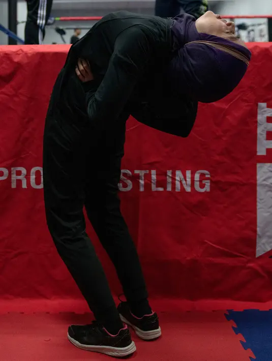 Pegulat hijab Malaysia, Nor "Phoenix" Diana melakukan pemanasan sebelum sesi latihan di gym di Kuala Lumpur pada 10 Juli 2019. Bertanding sebagai atlet gulat yang mengenakan hijab, Nor Diana berharap bisa menginspirasi pegulat lainnya, terutama para perempuan muda dan Muslim. (Mohd RASFAN/AFP)