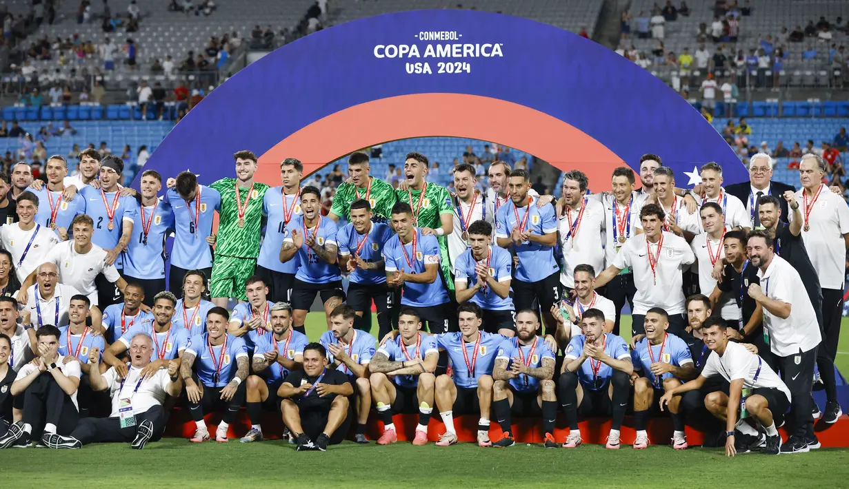 Para pemain Timnas Uruguay berfoto bersama di atas podium merayakan keberhasilan merebut posisi ketiga Copa America 2024 usai mengalahkan Timnas Kanada lewat babak adu penalti di Bank of America Stadium, Charlotte, Amerika Serikat, Minggu (14/7/2024) pagi WIB. (AP Photo/Nell Redmond)