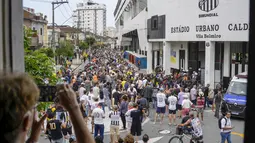 Warga Brasil mengantre untuk memberikan penghormatan terakhir kepada legenda sepak bola Brasil Pele di stadion Vila Belmiro di Santos, Brasil, Senin, 2 Januari 2023. Jenazah Pele akan dibawa melintas jalan-jalan Kota Santos dan melewati rumah sang ibunda Celeste yang berusia 100 tahun. Media Brasil menyebut ibu Pele tidak dalam keadaan sadar. (AP Photo/Matias Delacroix)