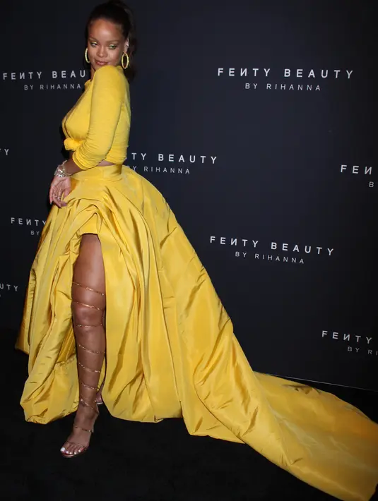 Rihanna berpose untuk fotografer setibanya pada peluncuran Fenty Beauty by Rihanna di Duggal Greenhouse, New York, Kamis (7/9). Penyanyi 29 tahun itu tampil percaya diri dalam balutan rok kuning menyala dengan belahan di bagian kanan. (AP Images Photo)