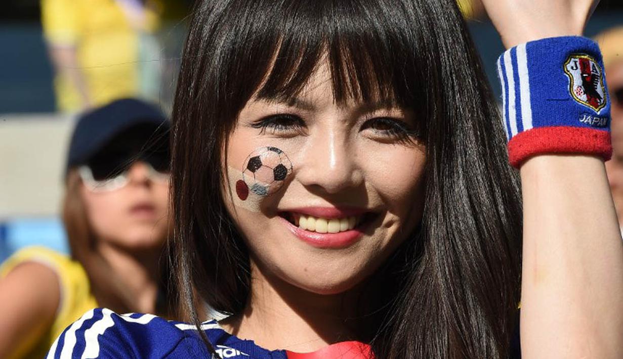  Senyum manis fans Jepang saat menunggu pertandingan antara jepang vs Kolombia di Pantanal Arena pada 24 Juni 2014 ( AFP PHOTO/LUIS ACOSTA)