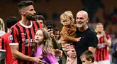 Penyerang AC Milan #09 Olivier Giroud dan putrinya Jade merayakan di samping pelatih AC Milan Stefano Pioli dan kerabatnya pada akhir pertandingan terakhir mereka saat melawan Salernitana dalam matchday terakhir Serie A di San Siro, Minggu (26/5/2024) dini hari WIB. (MARCO BERTORELLO / AFP)