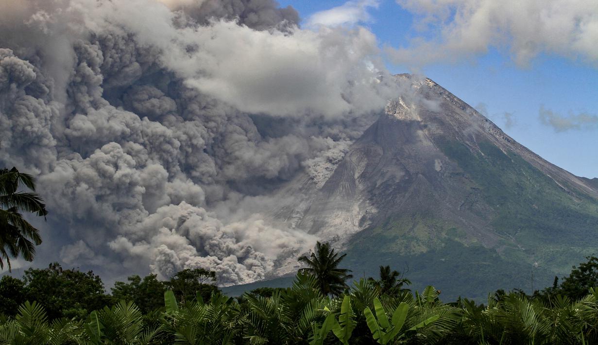Asap tebal mengepul saat erupsi Gunung Merapi terlihat dari desa Tunggularum di Sleman pada 11 Maret 2023. Gunung Merapi di perbatasan Provinsi Jawa Tengah dan Daerah Istimewa Yogyakarta (DIY) erupsi pada Sabtu (11/3/2023). Imbasnya, meluncurkan awan panas guguran ke arah Kali Bebeng atau Kali Krasak. (AFP/Devi Rahman)