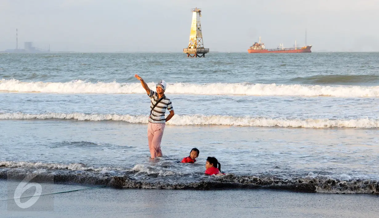 Sejumlah warga bermain air dipinggir Pantai Teluk Penyu Kabupaten Cilacap, Jawa Tengah,Jumat (29/7). Di Pantai Teluk Penyu pengunjung bisa memancing di tepian sambil menikmati terbenamnya matahari. (Liputan6.com/Helmi Afandi)