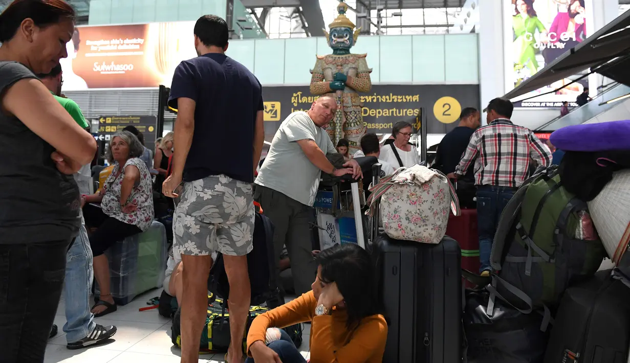 Sejumlah penumpang beristirahat di area check-in di Bandara Internasional Suvarnabhumi di Bangkok (28/2). Hampir Ribuan penumpang tujuan Pakistan dan Eropa terjebak di bandara tersebut. (AFP Photo/Lillian Suwnrumpha)