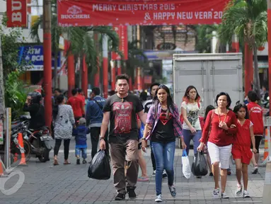 Sejumlah warga mengunjungi pusat perbelanjaan di Pasar Baru, Jakarta, Jumat (18/12). Menjelang Natal sejumlah pertokoan telah dihiasi berbagai aksesoris Natal dan berbagai harga promo serta potongan harga. (Liputan6.com/Gempur M Surya)