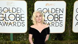 Penyanyi Lady Gaga berpose di karpet merah ajang penghargaan film tahunan, Golden Globes 2016 di Beverly Hilton Hotel, California, Minggu (10/1). Pelantun hits 'Judas' tersebut tampil glamour dengan gaun hitam Versace.  (Jason Merritt/Getty Images/AFP)