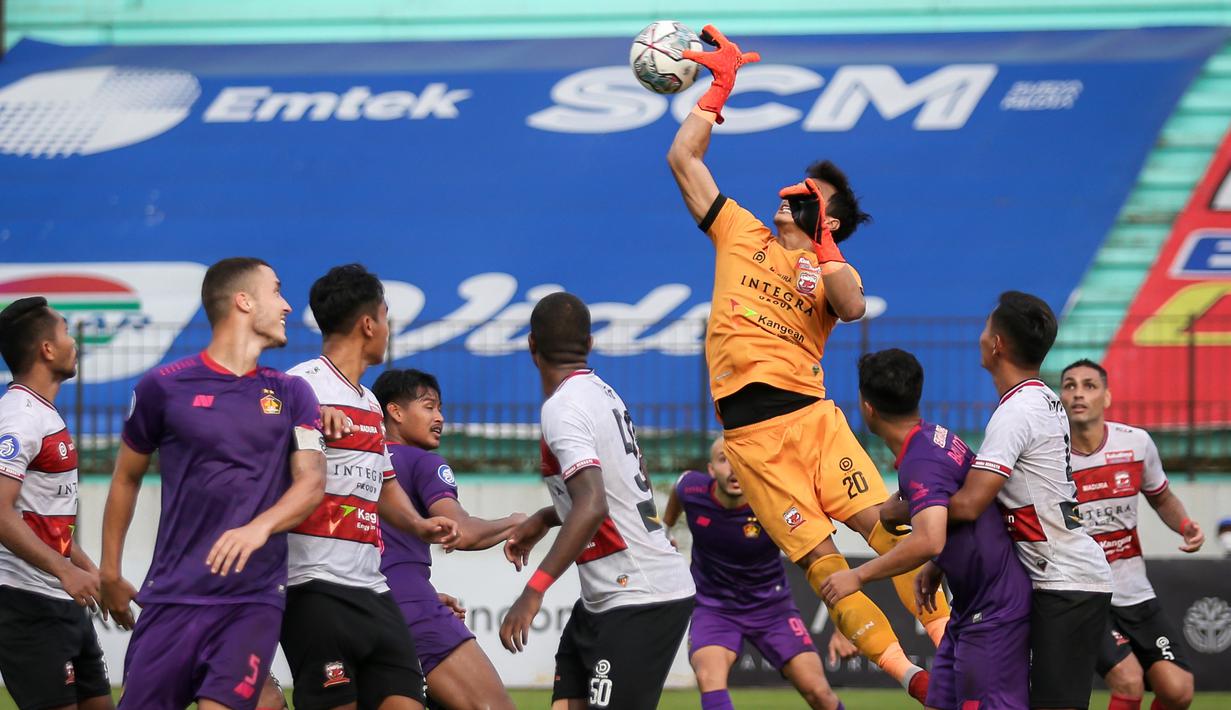 Kiper Madura United, Muhammad Ridho (atas) berusaha menghalau bola saat melawan Persik Kediri dalam laga pekan ke-13 BRI Liga 1 2021/2022 di Stadion Moch. Soebroto, Magelang, Rabu (24/11/2021). (Bola.com/Bagaskara Lazuardi)