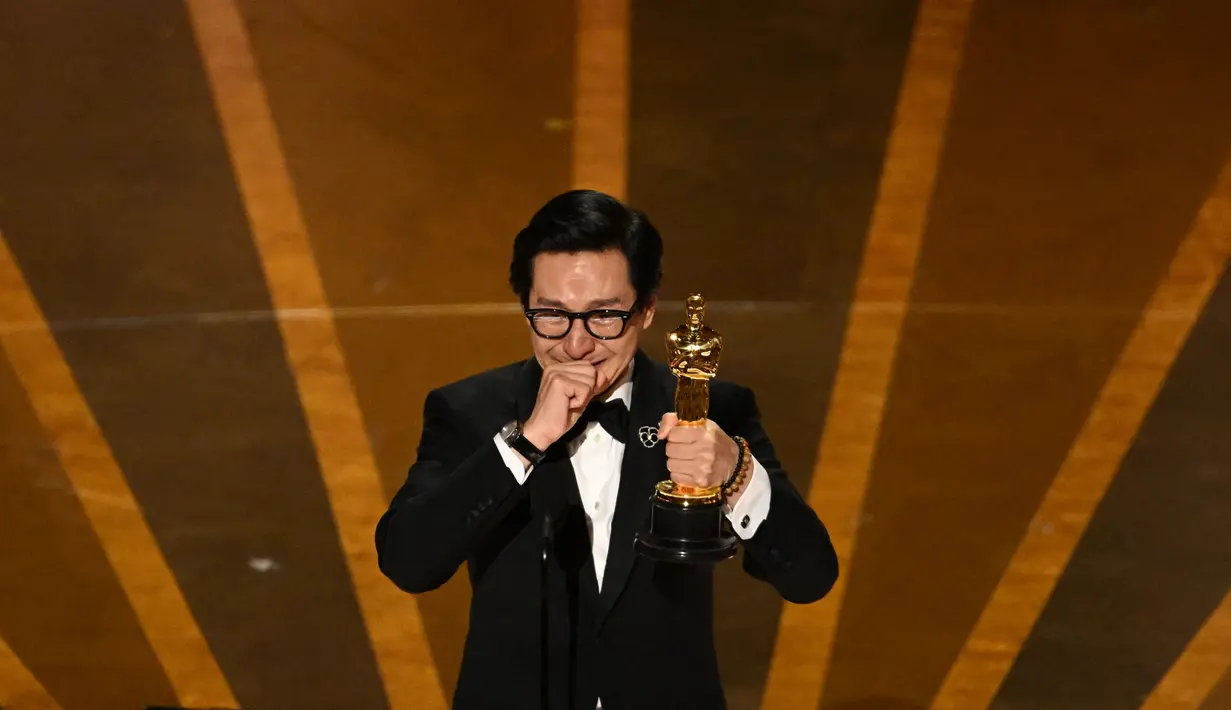 Aktor AS-Vietnam Ke Huy Quan menerima Piala Oscar kategori Pemeran Pendukung Pria Terbaik pada penghargaan Academy Awards ke-95 di Dolby Theatre di Hollywood, California, Minggu (12/3/2023). Ke Huy Quan mendapatkan kemenangan pertamanya sebagai Best Actor in Supporting Role dalam film EVERYTHING EVERYWHERE ALL AT ONCE setelah puluhan tahun vakum dari dunia akting. (Photo by Patrick T. Fallon / AFP)