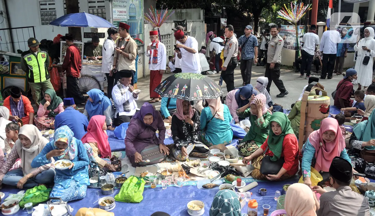 Warga makan bersama saat Lebaran Kukusan di Kukusan, Depok, Jawa Barat, Minggu (30/4/2023). (merdeka.com/Iqbal S. Nugroho)