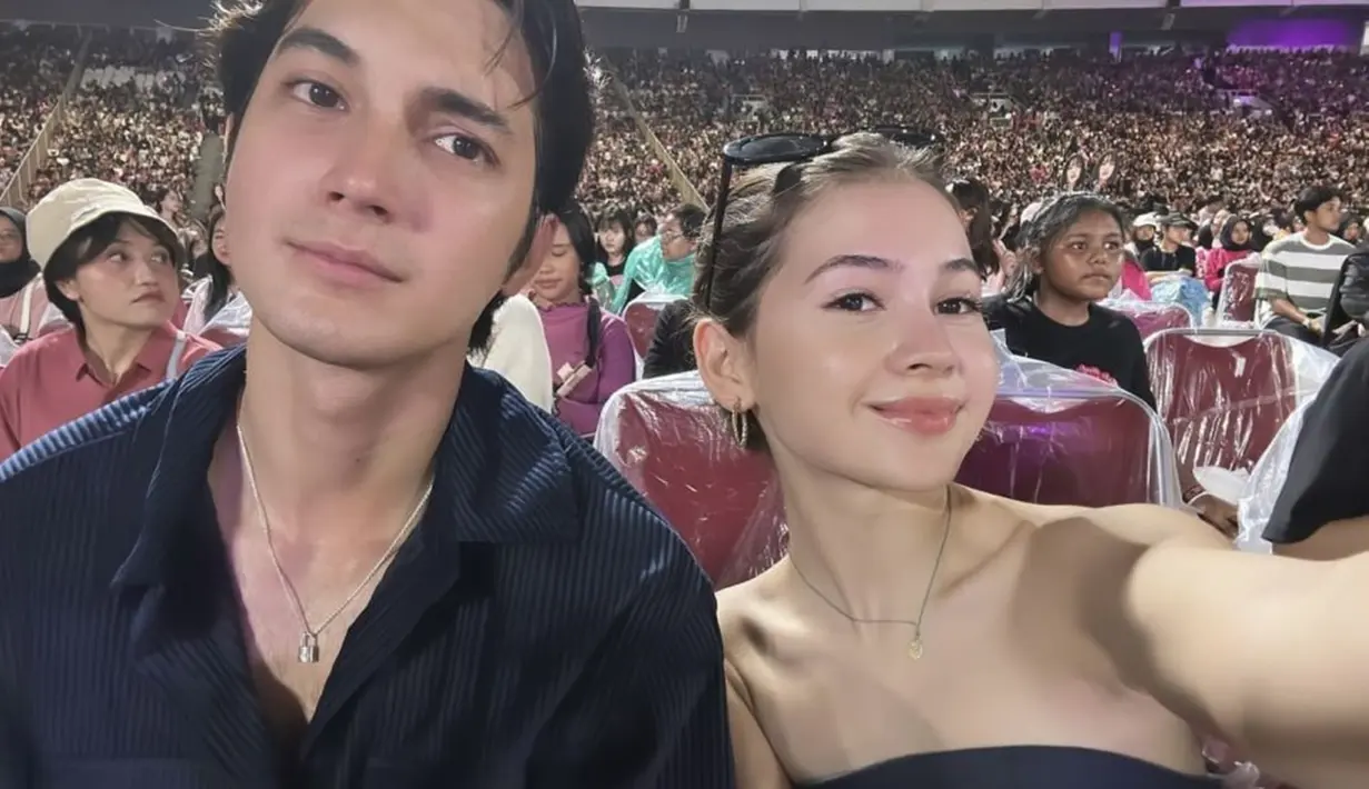 Sandrinna dan Junior Roberts nonton konser Blackpink di hari pertama di bangku platinum. Pakai outfit warna hitam, pasangan yang terpaut usia 7 tahun ini makin selaras. Kenakan baju model kemben, penampilan Sandrinna Michelle disorot karena terlalu dewasa dan tak sesuai usianya. Komentar negatif ramai dibubuhkan, Sandrinna tutup kolom komentar. Dalam unggahannya, Sandrinna dan Junior Robert menikmati konser dan nyanyi bareng lagu Lovesick Girl. (Liputan6.com/IG/@sandrinna_11)
