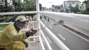 Petugas Sudin Bina Marga Jakarta Timur memperbaiki jembatan penyeberangan orang (JPO) di Jalan Otto Iskandardinata (Otista), Jatinegara, Rabu (9/2/2022). Perbaikan JPO itu tindak lanjut pasca insiden tertimpa pohon tumbang pada November tahun lalu akibat cuaca ekstrem. (merdeka.com/Iqbal S Nugroho)