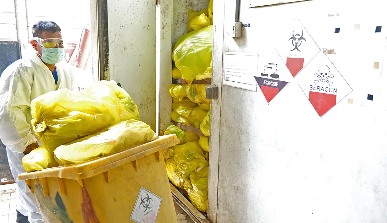 Petugas mengambil limbah medis di TPS untuk proses pembakaran ke incinerator di RSCM Jakarta, Jumat (26/6/2020). Menteri Lingkungan Hidup Siti Nurbaya Bakar menyebutkan volume limbah medis infeksius di seluruh Indonesia hingga 8 Juni 2020 mencapai lebih dari 1.100 ton. (Liputan6.com/Herman Zakharia)