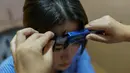 Dokter Wang Yang melakukan pengukuran wajah Yu Linlin saat sesi konsultasi di Huamei Medical Cosmetology Hospital di Shanghai, Tiongkok (22/9). Operasi plastik di Tiongkok meningkat didorong oleh kenaikan pendapatan. (AFP Photo/Chandan Khanna)