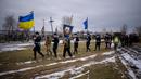 Peti mati Oleksandr Maksymenko (38) dibawa oleh petugas Ukraina selama pemakamannya di kampung halamannya di Kniazhychi, sebelah timur Kyiv, Ukraina, 13 Februari 2023. Oleksandr Maksymenko, seorang warga sipil yang menjadi sukarelawan di angkatan bersenjata Ukraina, tewas dalam pertempuran di daerah Bakhmut. (AP Photo/Emilio Morenatti)