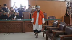 Terpidana kasus pelemparan bom molotov ke Gereja Oikumene, Samarinda, Joko Sugito, menuju kursi untuk bersaksi pada sidang lanjutan terdakwa bom Thamrin, Aman Abdurrachman di Pengadilan Negeri Jakarta Selatan, Selasa (27/3). (Liputan6.com/Herman Zakharia)