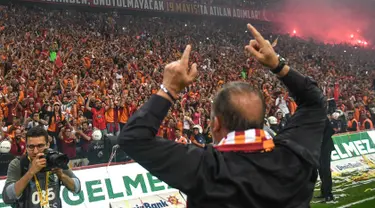 Pelatih Galatasaray Fatih Terim menyapa suporter saat merayakan gelar Liga Turki usai pertandingan melawan Istanbul Basaksehir di Turk Telekom Arena di Istanbul (19/5/2019). Galatasaray memastikan gelar liga Turki ke-22 usai mengalahkan Istanbul Basaksehir 2-1. (AFP Photo/Bulent Kilic)