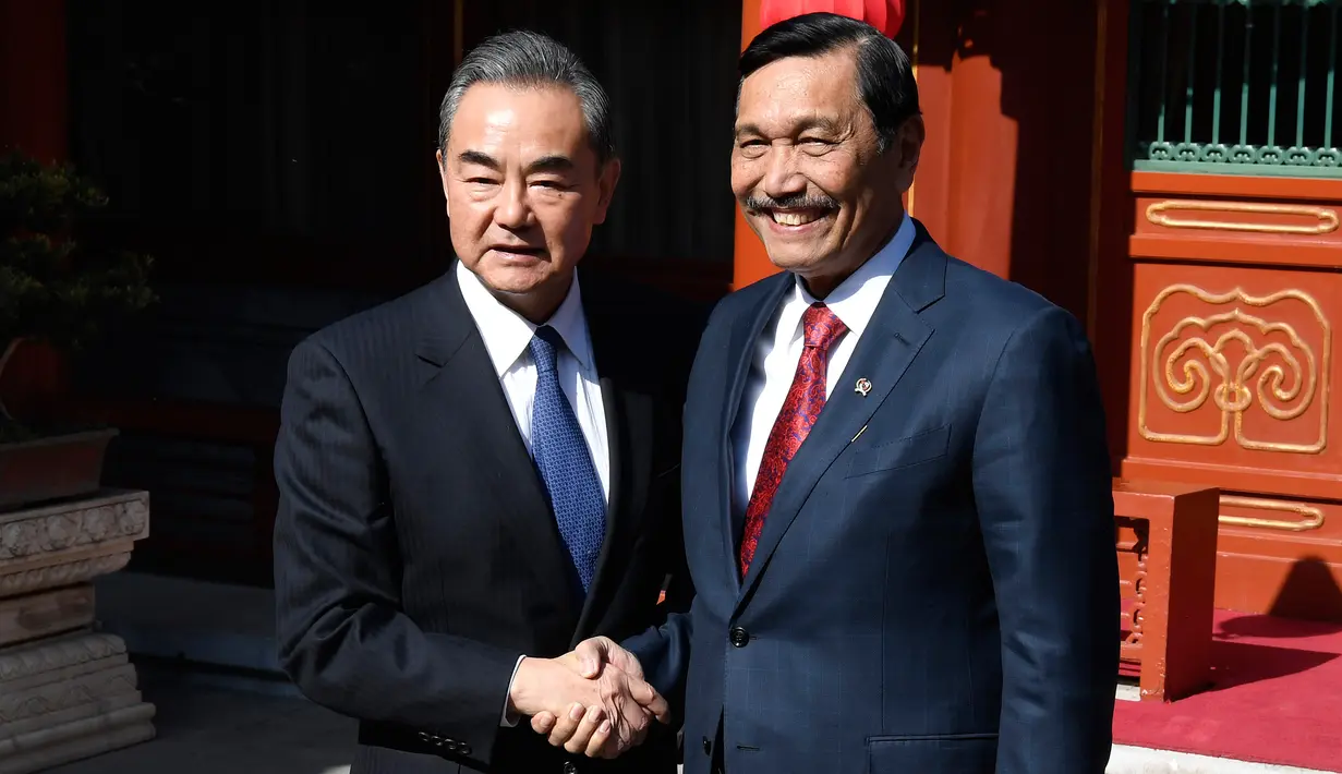 Menteri Luar Negeri China, Wang Yi berjabat tangan dengan Menko Kemaritiman Indonesia, Luhut Pandjaitan sebelum melakukan pertemuan di Wisma Negara Diaoyutai, Beijing. Rabu (24/10). (Daisuke Suzuki/Pool via AP)