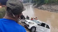 Emak-emak yang sedang belajar mengemudikan mobil nyemplung di aliran anak Sungai Bengawan Solo, Rabu (15/3).(Liputan6.com/Fajar Abrori)