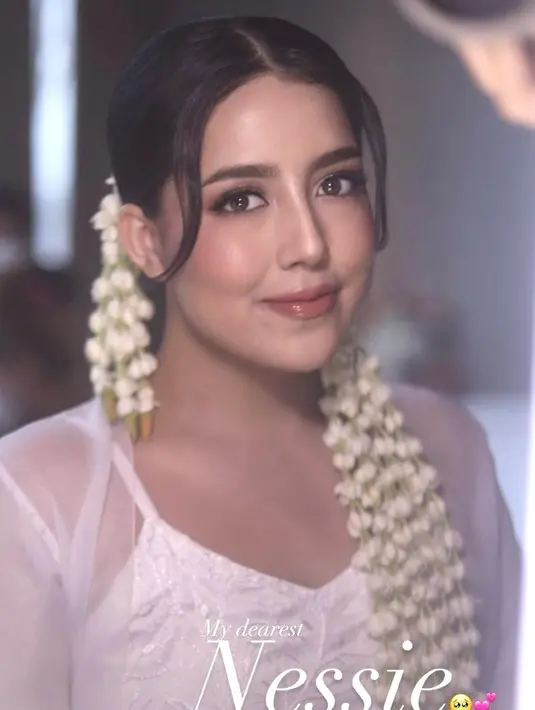 Saat akad, wajah Nessie dipulas dengan makeup bergaya soft glam. Tampak shading yang tegas, soft eye look, fresh coral blush,  dan glossy lips. [@vinnagracia]