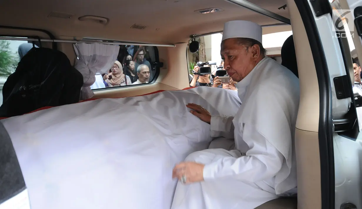 Wakil Presiden ke-9 RI, Hamzah Haz memegang peti jenazah istrinya, Asmaniah jelang diberangkatkan dari rumah duka di Jakarta, Selasa (12/9). Jenazah akan dimakamkan di pemakaman keluarga di Bogor, Jawa Barat. (Liputan6.com/Helmi Fithriansyah)