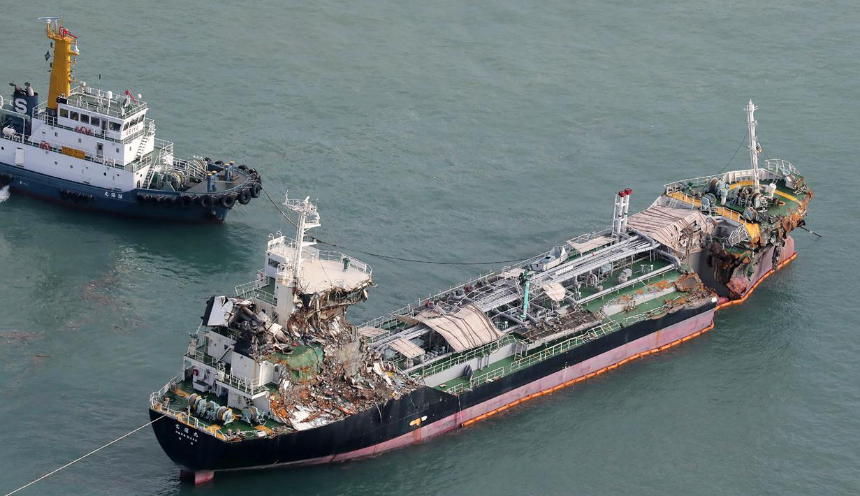 Pemandangan udara dari helikopter Jiji Press menunjukkan sebuah kapal tanker minyak ditarik setelah bertabrakan dengan jembatan yang menghubungkan ke Bandara Internasional Kansai di kota Izumisano, prefektur Osaka (5/9). (AFP Photo/Jiji Press)