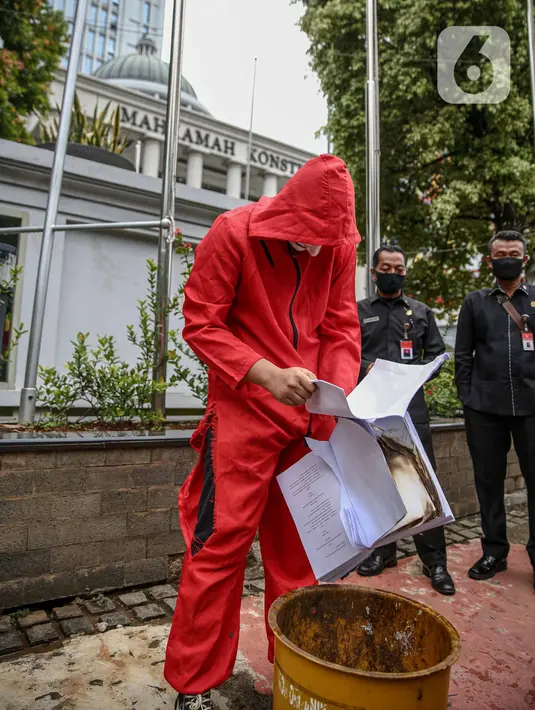 Seorang mahasiswa dari Mahasiswa Independen secara simbolis membakar salinan naskah UU Cipta Kerja di depan Gedung MK, Jakarta, Selasa (27/10/2020). Mahasiswa menyatakan aksi tersebut bentuk ketidakpercayaan kepada MK bila proses uji materi UU Cipta Kerja dilakukan. (Liputan6.com/Faizal Fanani)