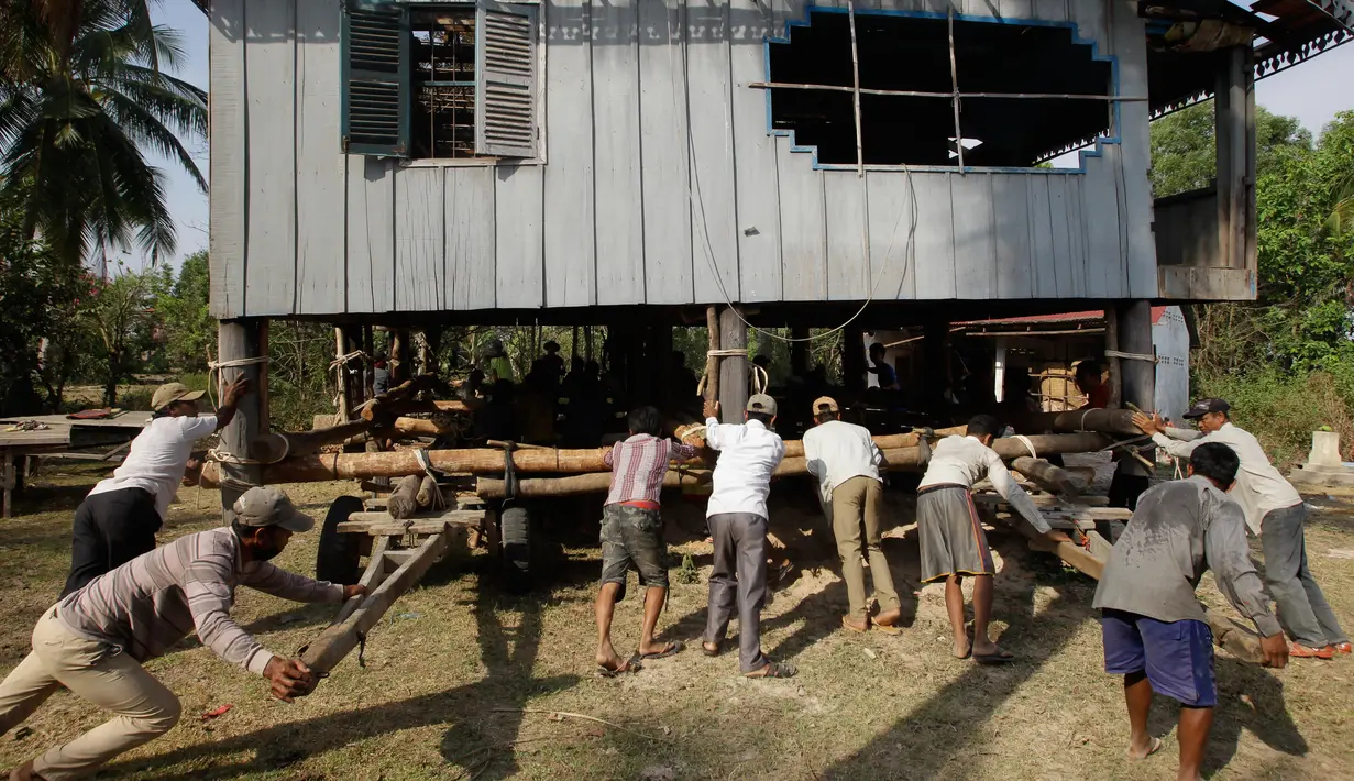 Warga bergotong royong memindahkan rumah di Desa Serey Andet di provinsi Kampong Speu, Kamboja (27/3). (AP Photo/Heng Sinith)