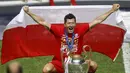 Penyerang Bayern Munchen, Robert Lewandowski berpose dengan bendera Polandia dan trofi Liga Champions setelah mengalahkan PSG pada pertandingan final di stadion Luz di Lisbon (23/8/2020). Munchen menang tipis atas PSG 1-0. (AFP/Pool/Matthew Childs)