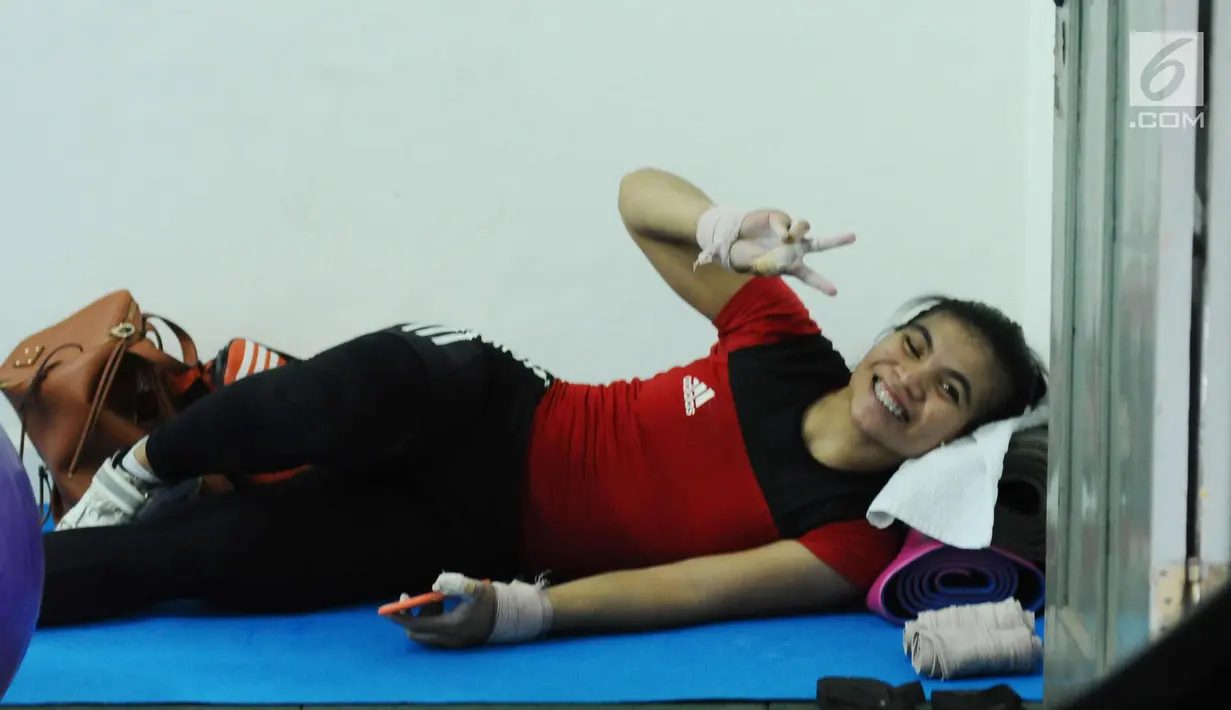 Lifter putri Sri Wahyuni beristirahat disela-sela latihan jelang tes prestasi pelatnas angkat besi Asian Games 2018 di Mako Lanmar Jakarta, Selasa (6/3). Tes ini untuk mengukur kemajuan atlet jelang Asian Games 2018. (Liputan6.com/Helmi Fithriansyah)