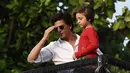 Aktor Bollywood, Shah Rukh Khan menggendong putranya, Abram Khan menyapa para fans yang berkumpul di depan rumahnya pada perayaan Idul Fitri di Mumbai, Rabu (5/6/2019). Ribuan penggemar kerap berkumpul di depan rumah Shah Rukh Khan di momen-momen tertentu. (SUJIT JAISWAL/AFP)