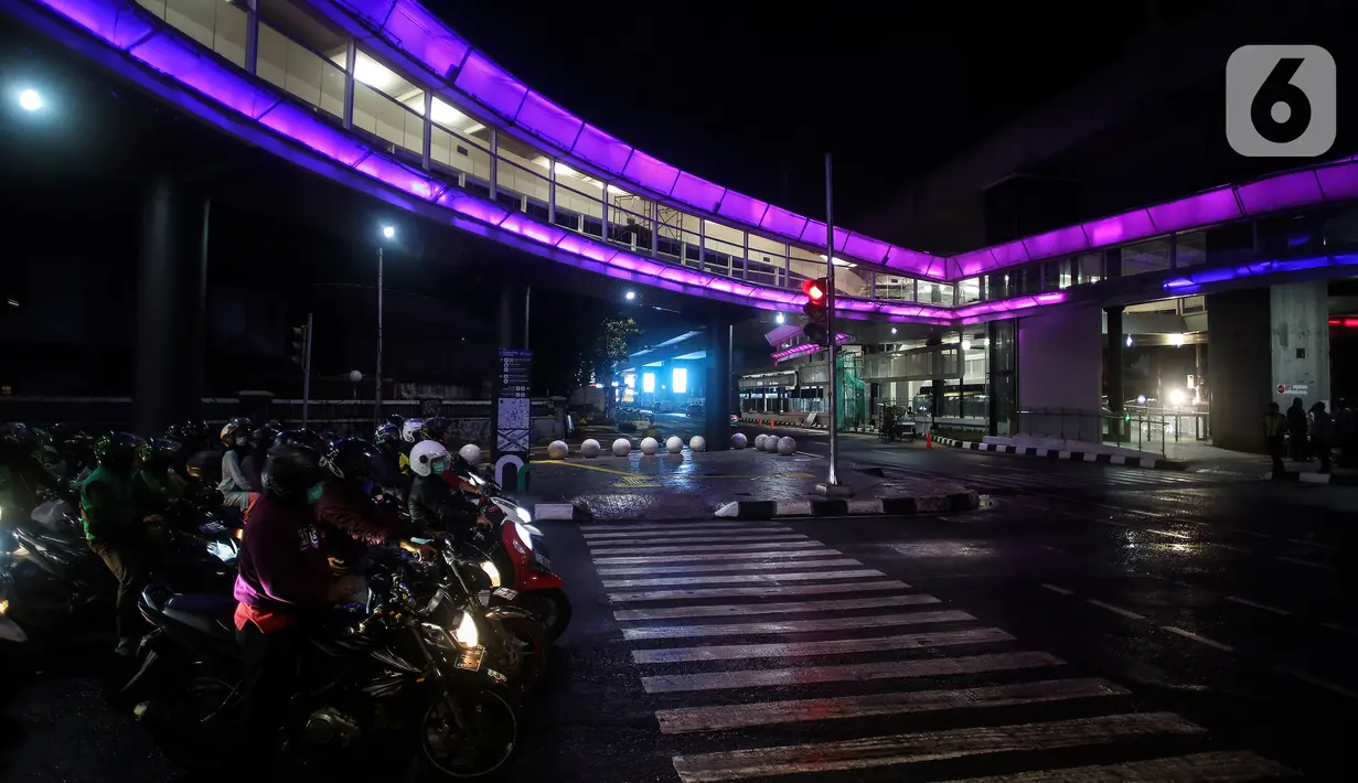 Kendaraan melintas dekat halte CSW yang berhiaskan lampu warna-warni di Kawasan Kebayoran Baru, Jakarta, Kamis (5/8/2021). Proyek pembangunan skybridge untuk integrasi Halte Transjakarta CSW dengan Stasiun MRT ASEAN itu mengusung konsep desain Cakra Selaras Wahana. (Liputan6.com/Johan Tallo)