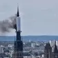 Asap terlihat mengepul dari bawah penutup yang mengelilingi puncak menara  katedral Gotik yang terkenal di Kota Rouen, Prancis. (AFP)