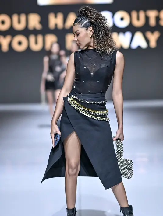 Rambut keritingnya ditata dengan kepang bertingkat yang diikat ponytail tinggi [JFW 2026]