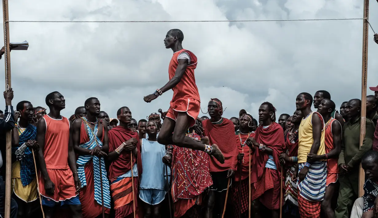 Pria suku Masaai melompat untuk mencapai tali selama mengikuti Olimpiade Maasai 2018 di Kimana, Kenya (15/12). Olimpiade ini inisiatif dari kelompok konservasi internasional yang dipimpin oleh Born Free. (AFP Photo/Yasuyoshi Chiba)