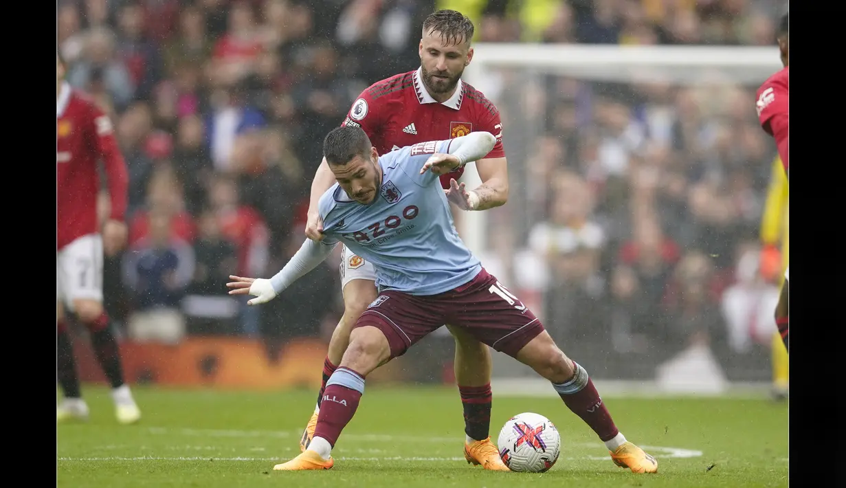 Pemain Manchester United, Luke Shaw (kanan), berusaha menutup pergerakan dari pemain Aston Villa, Emiliano Buendia, dalam pertandingan pekan ke-34 Liga Inggris 2022/2023 yang berlangsung di Old Trafford, Minggu (30/4/2023). (AP Photo/Dave Thompson)